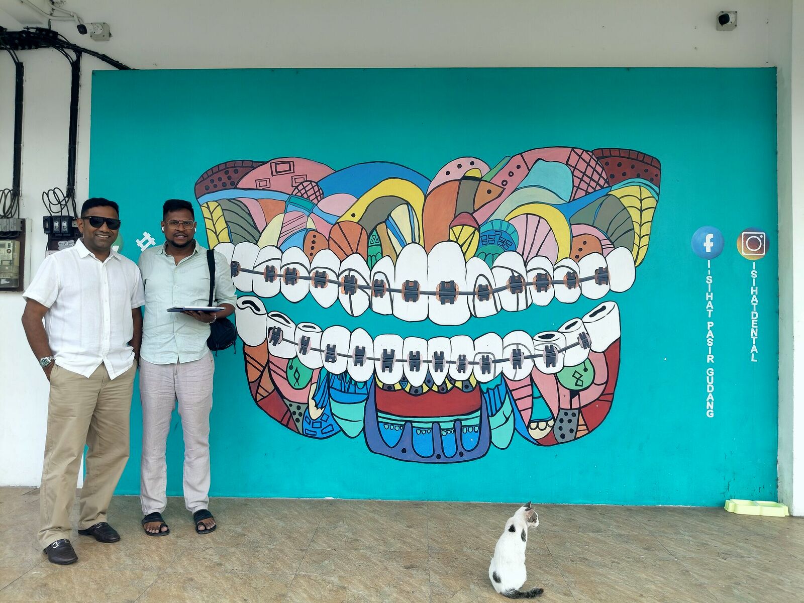 Our founder with a client at their dental clinic wall